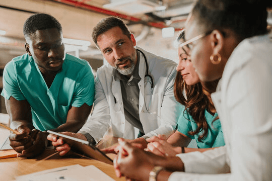 Diverse clinical team reviewing a case together — dose timing intelligence for prescribing clinicians